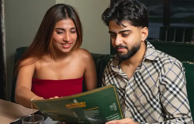 Couple deciding what to order from the Bombay Canteen menu