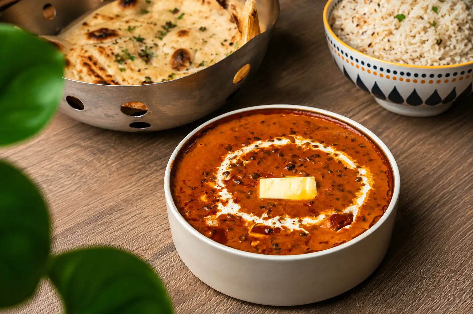 Bowl of creamy Dal Makhani with butter, served with rice and naan bread